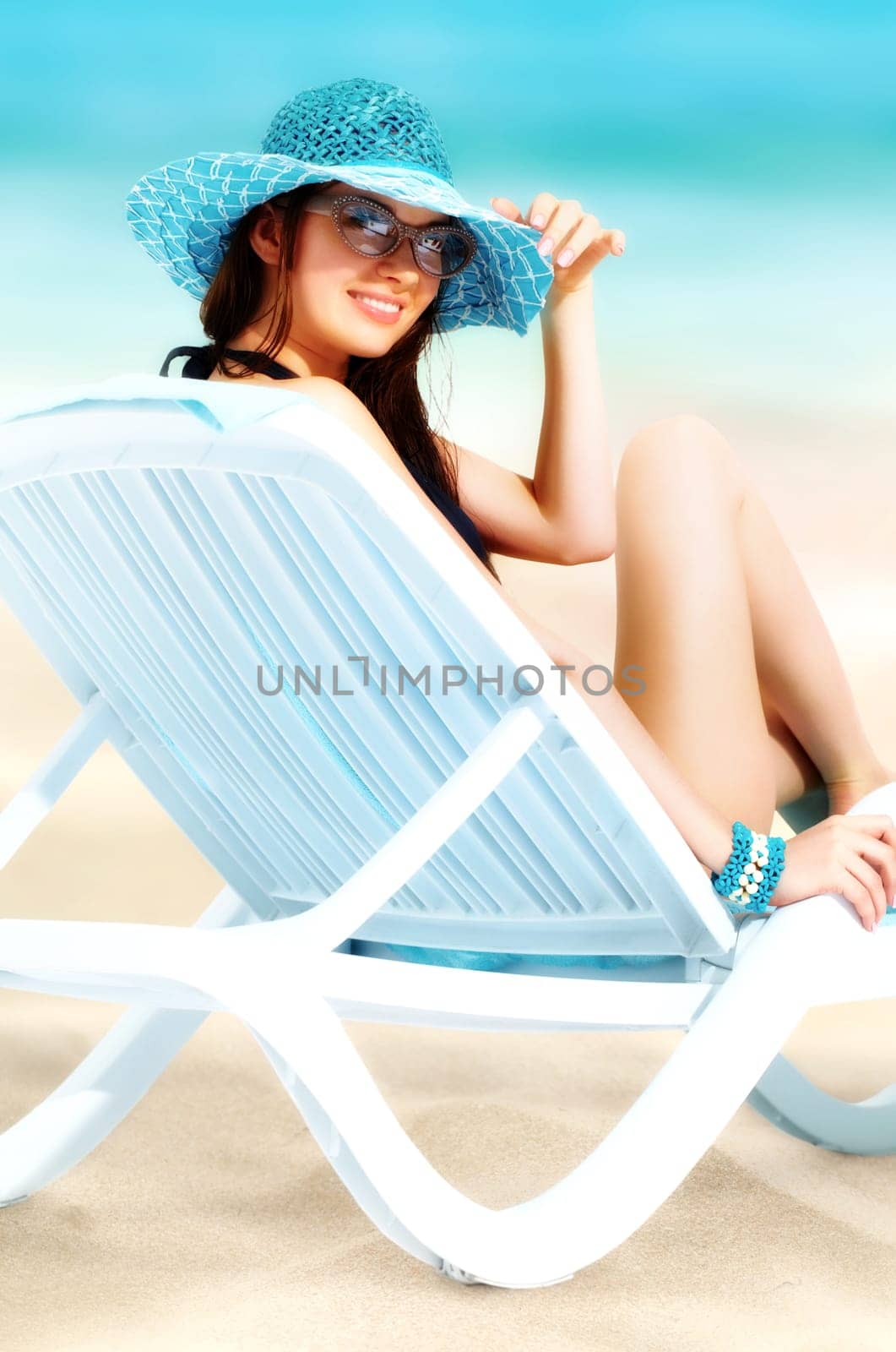 Portrait of a young smiling girl sitting in chaise lounge