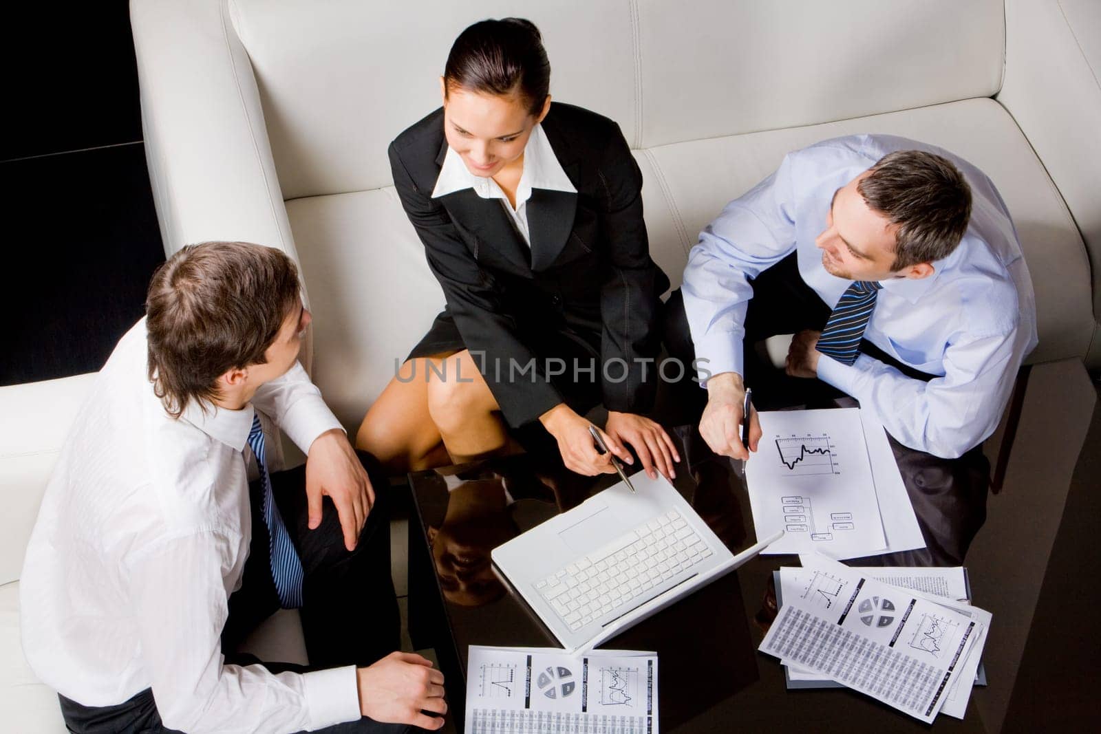 Three busisness partners sitting around table and planning work at briefing