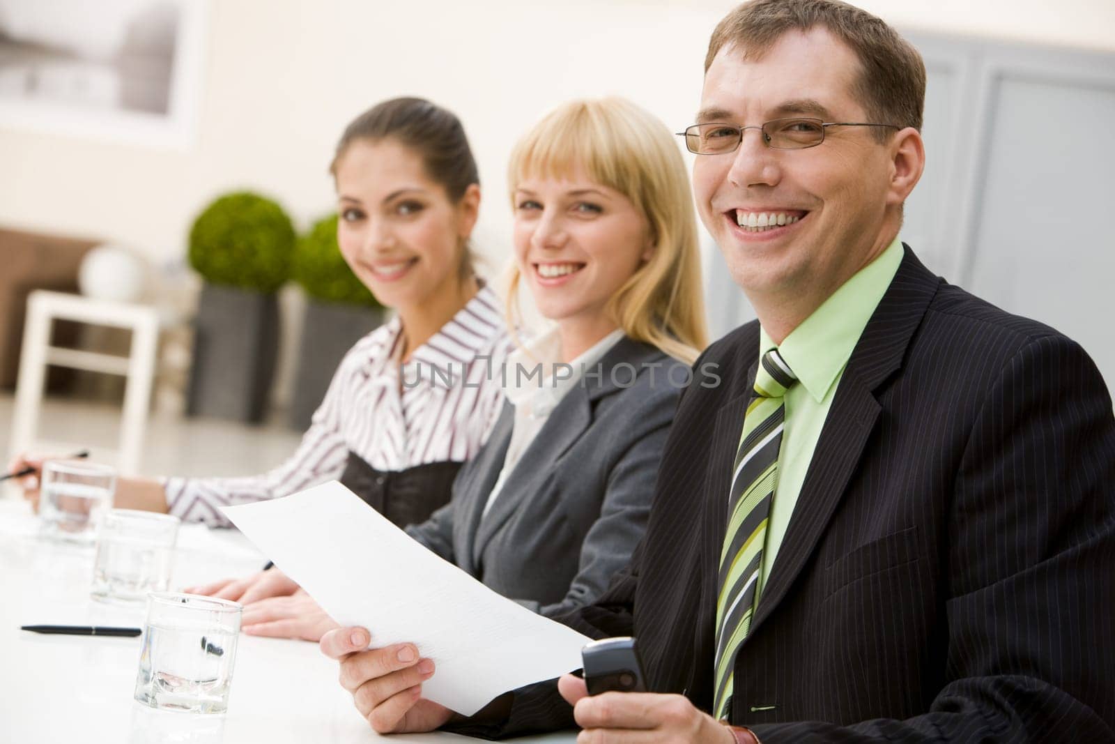 Portrait of attractive male looking at camera with his partners on background