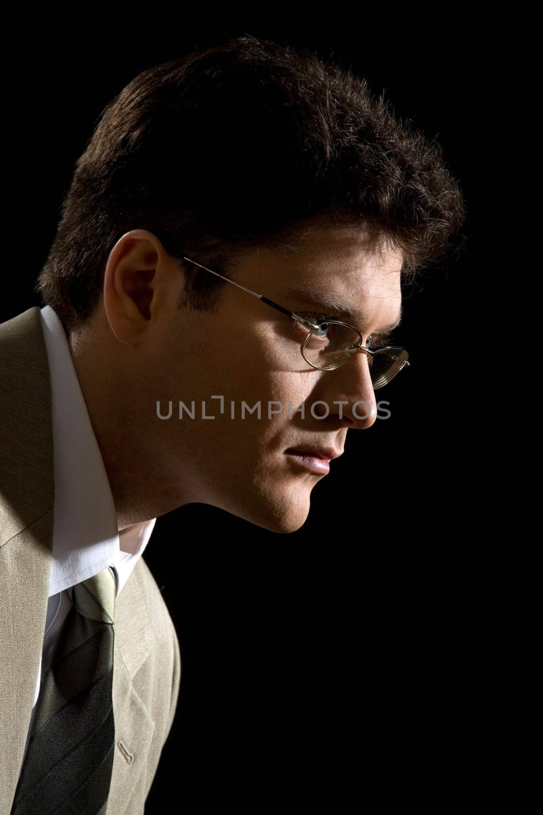 Portrait of serious male in suit over black background