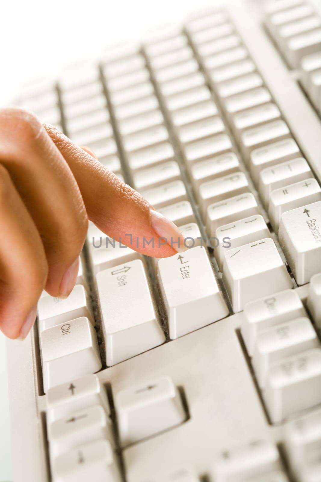 Close-up of female finger on the key of white keyboard