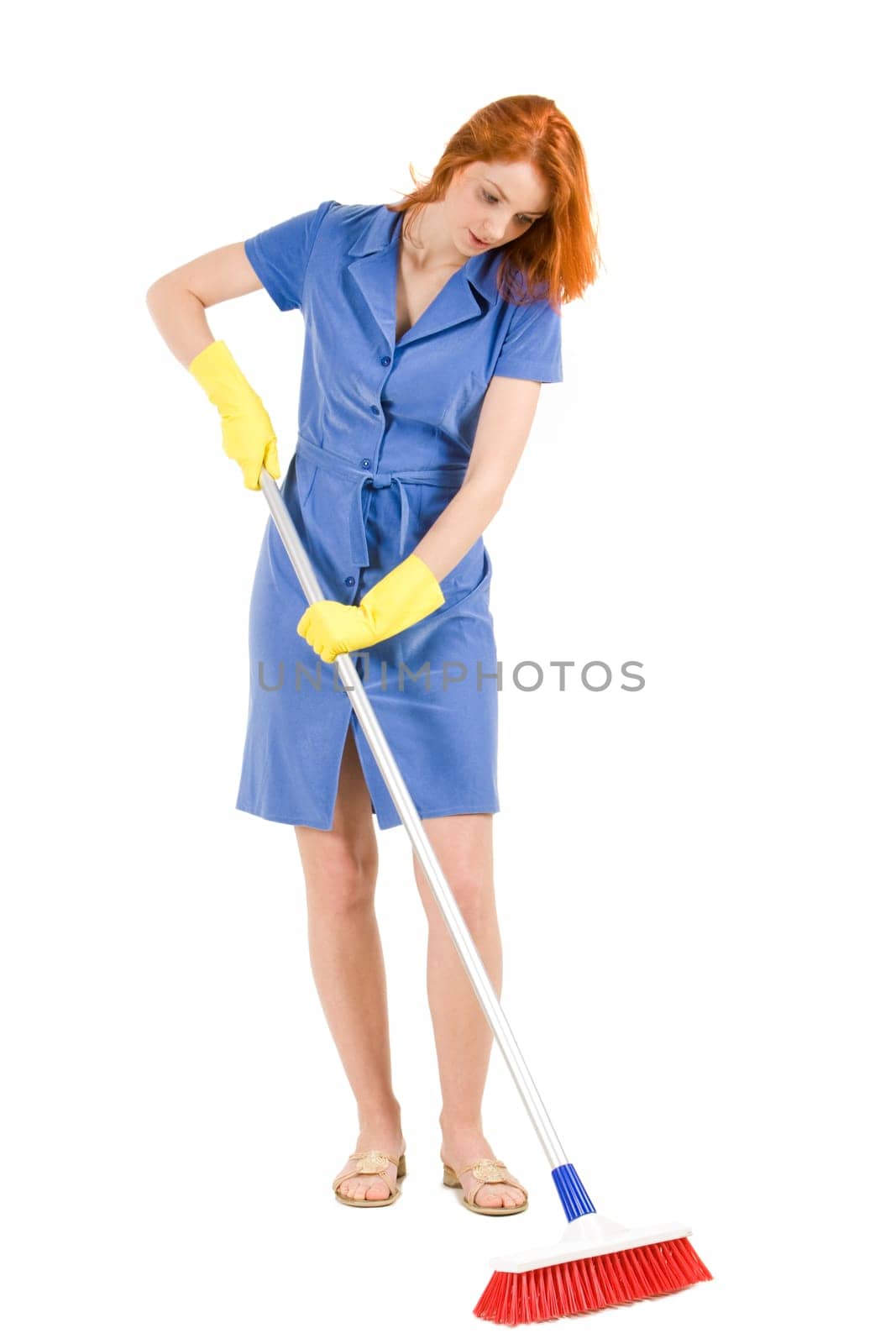 Portrait of nice housewife in blue robe doing housework with brush