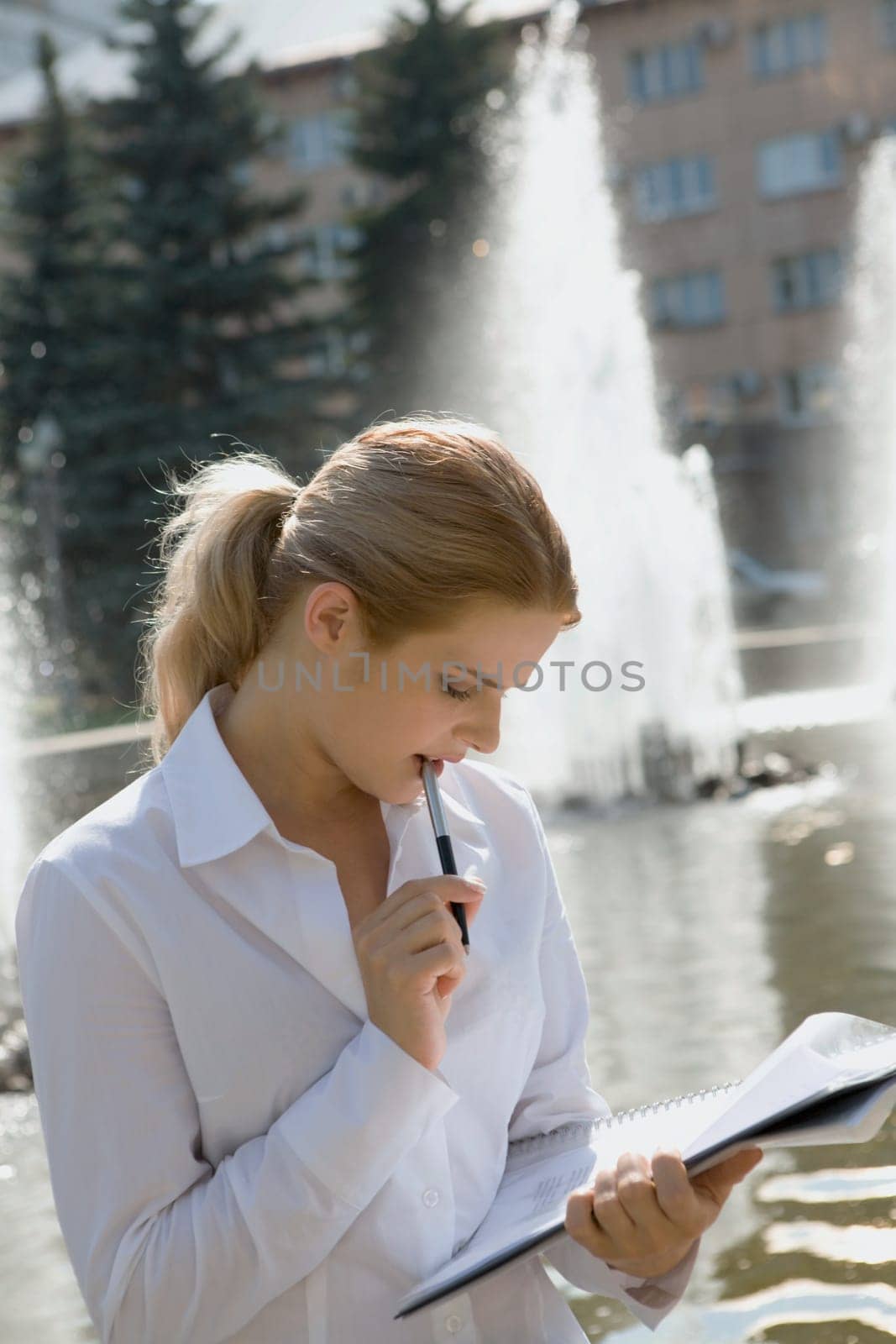 Portrait of pretty business woman reading an interesting agreement in the park