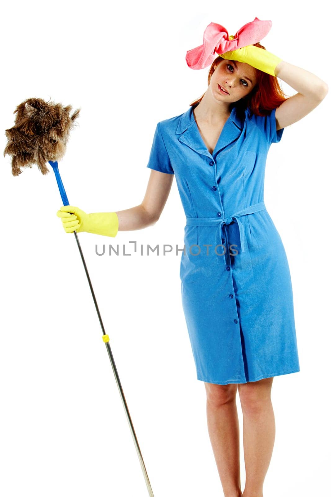 Portrait of nice housewife wearing blue robe with brush and duster in hands