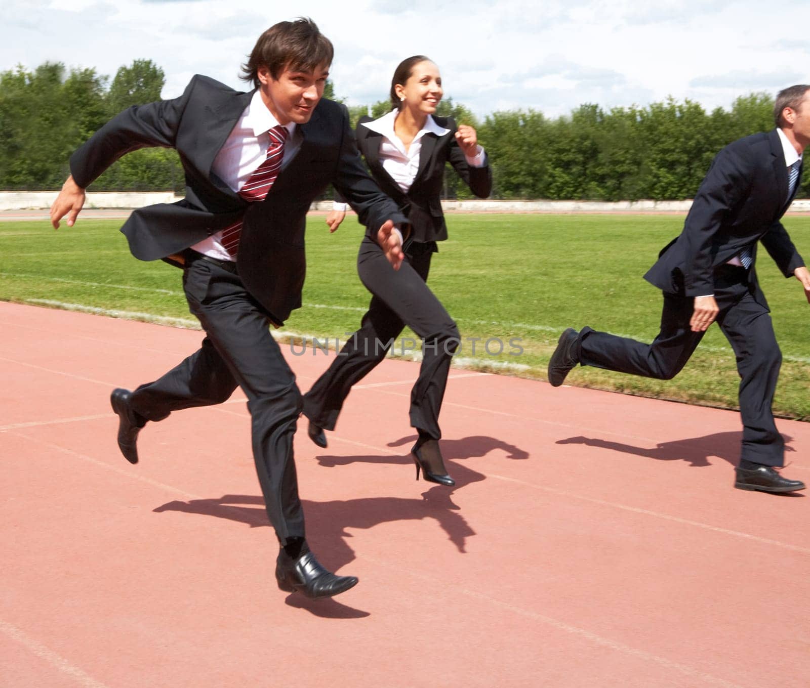 Photo of energetic business people in suits running