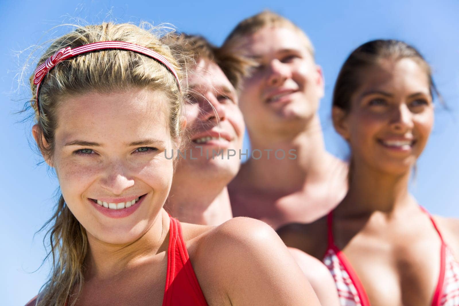 Face of charming girl looking at camera with group of friends behind