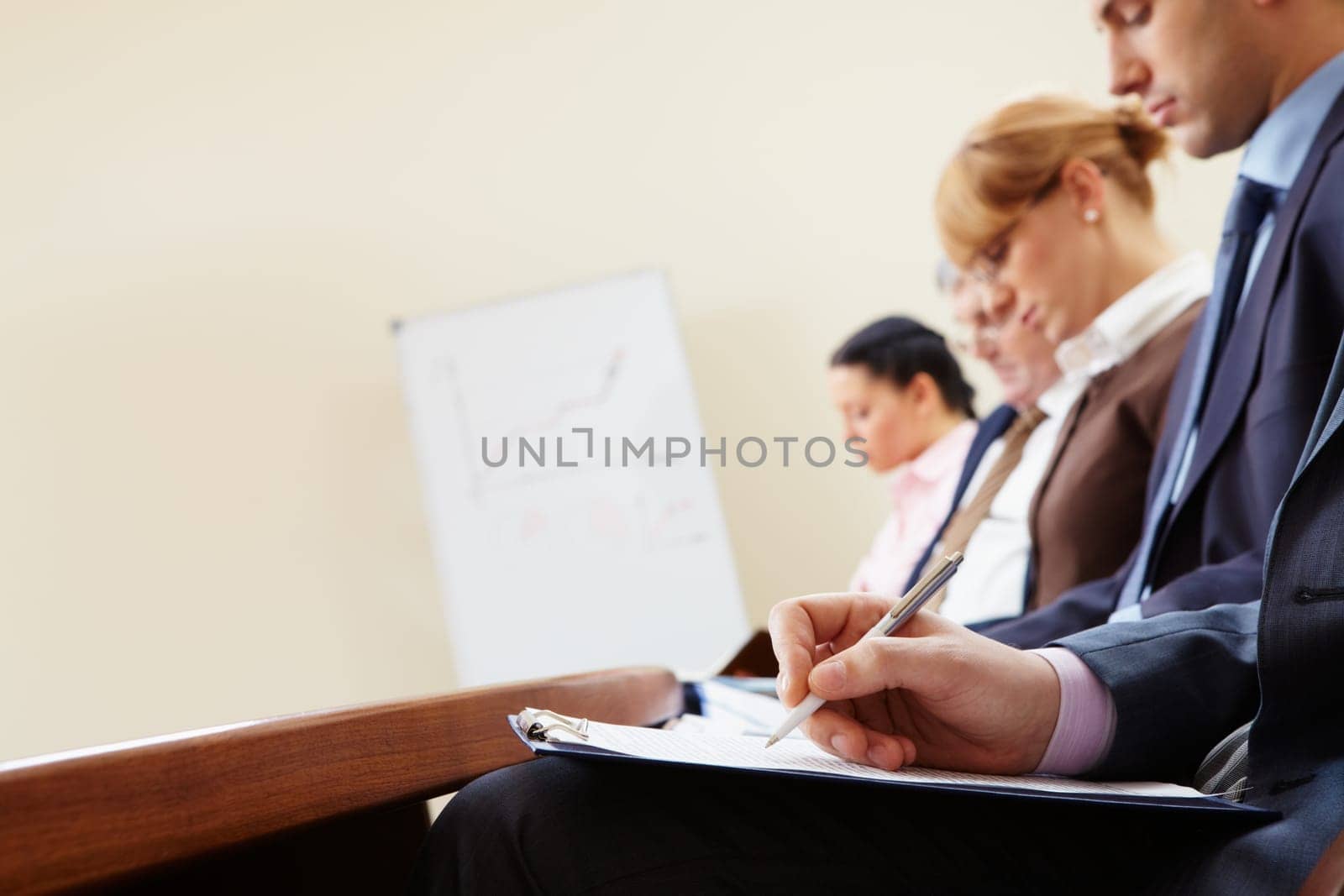 Close-up of businesspeople hands with documents writing at lecture