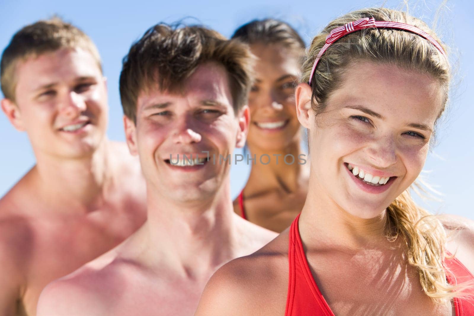 Portrait of pretty female looking at camera with smile on background of her friends