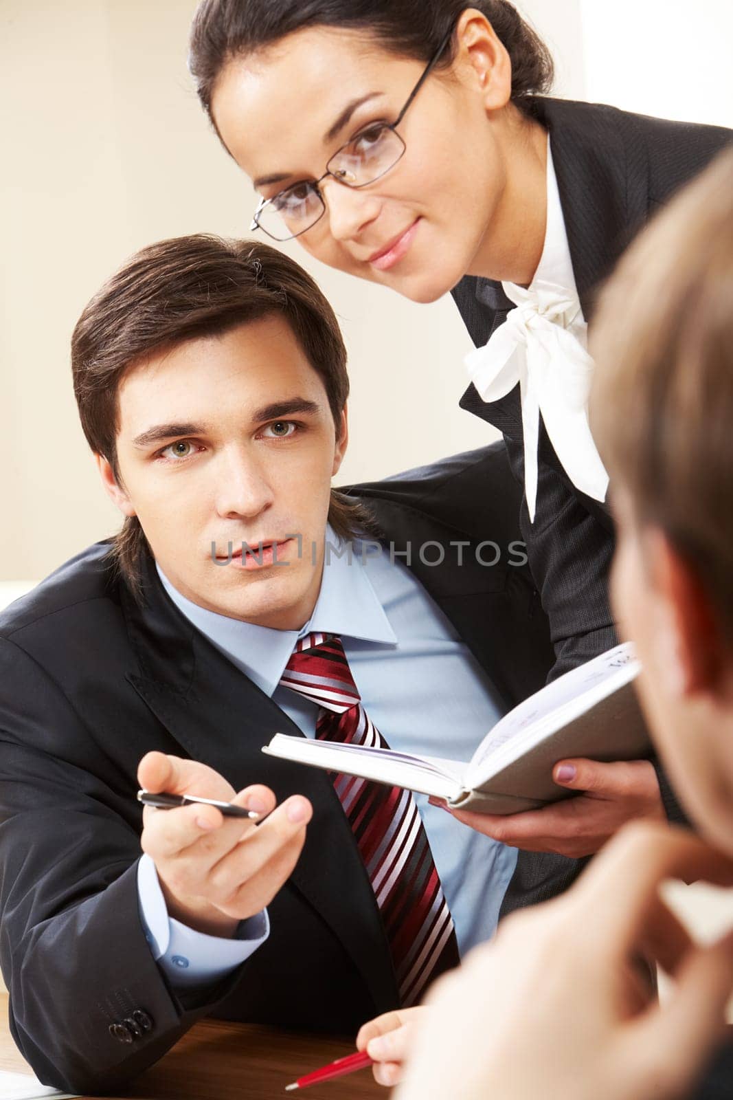 Photo of serious businessman looking at his partner with pretty female near by