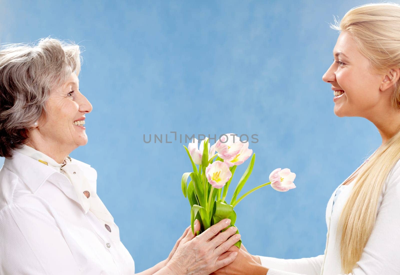 Portrait of young woman giving tulips to her mother
