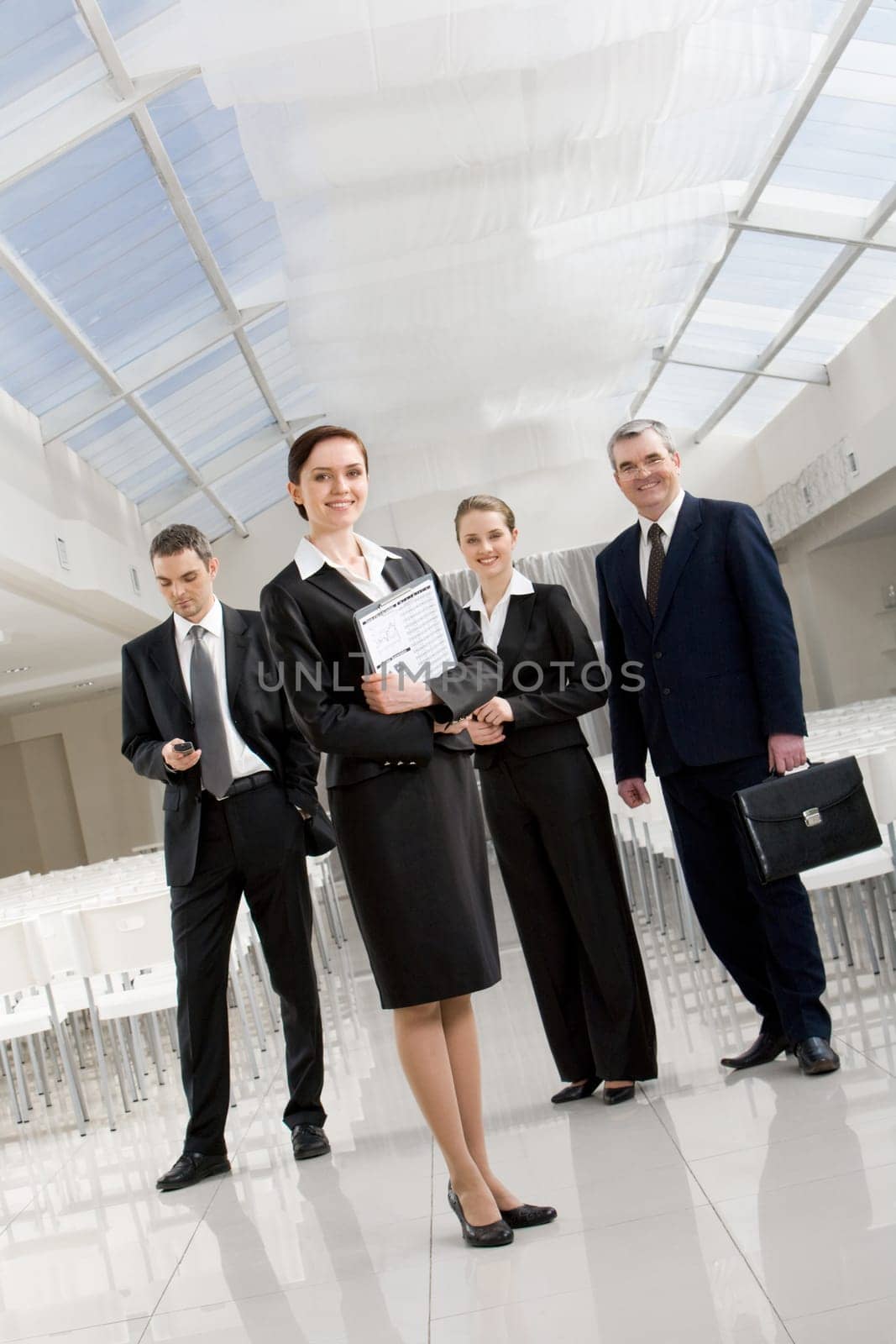 Portrait of successful business partners standing in conference hall and looking at camera