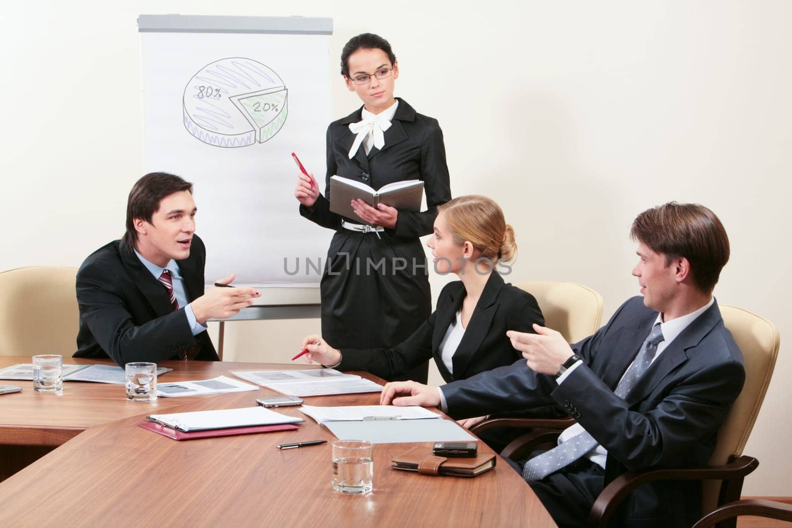 Image of successful people sitting around table and sharing experience with elegant female listening to them attentively