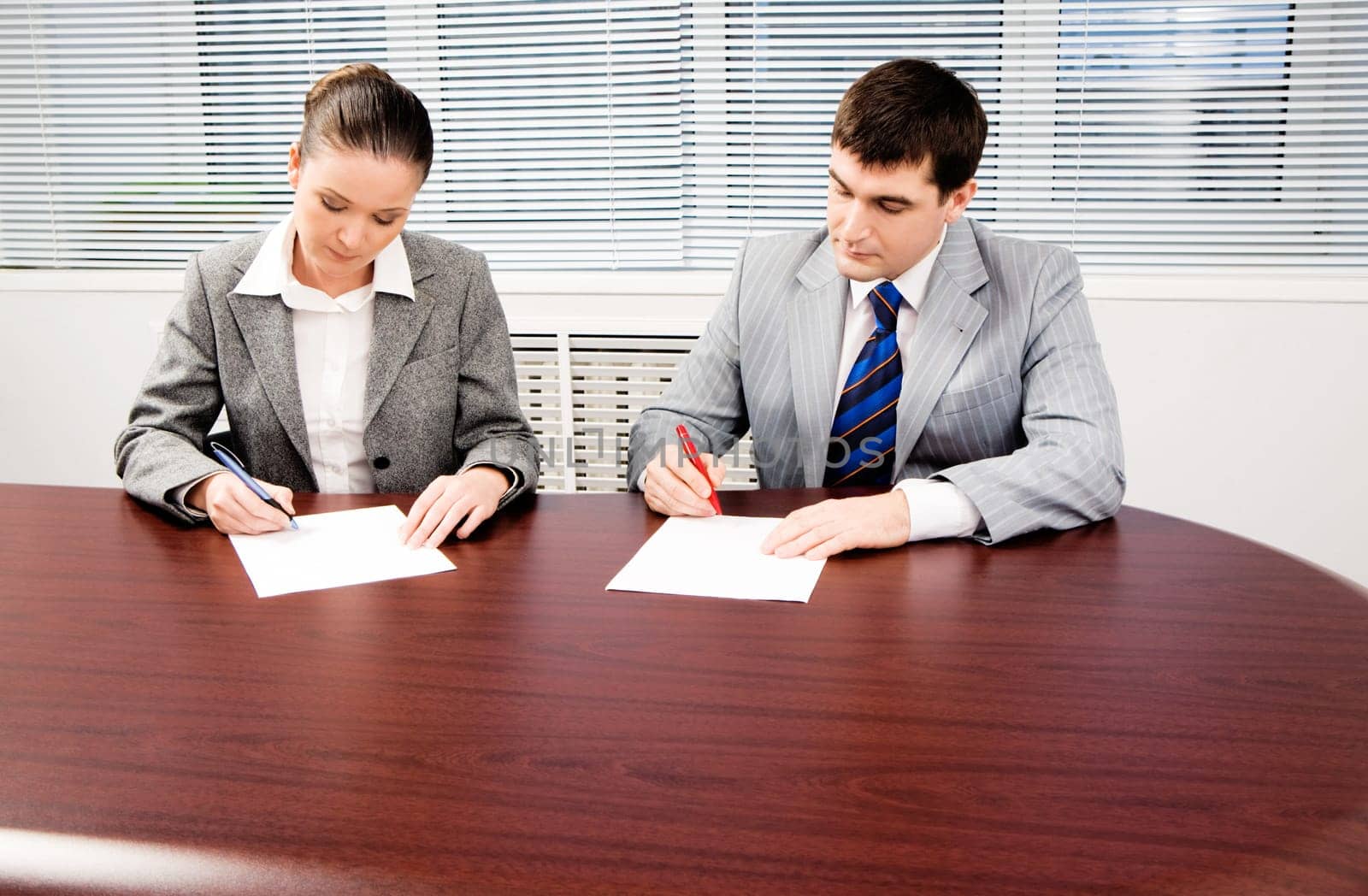 Photo of confident business partners writing down plan in the office