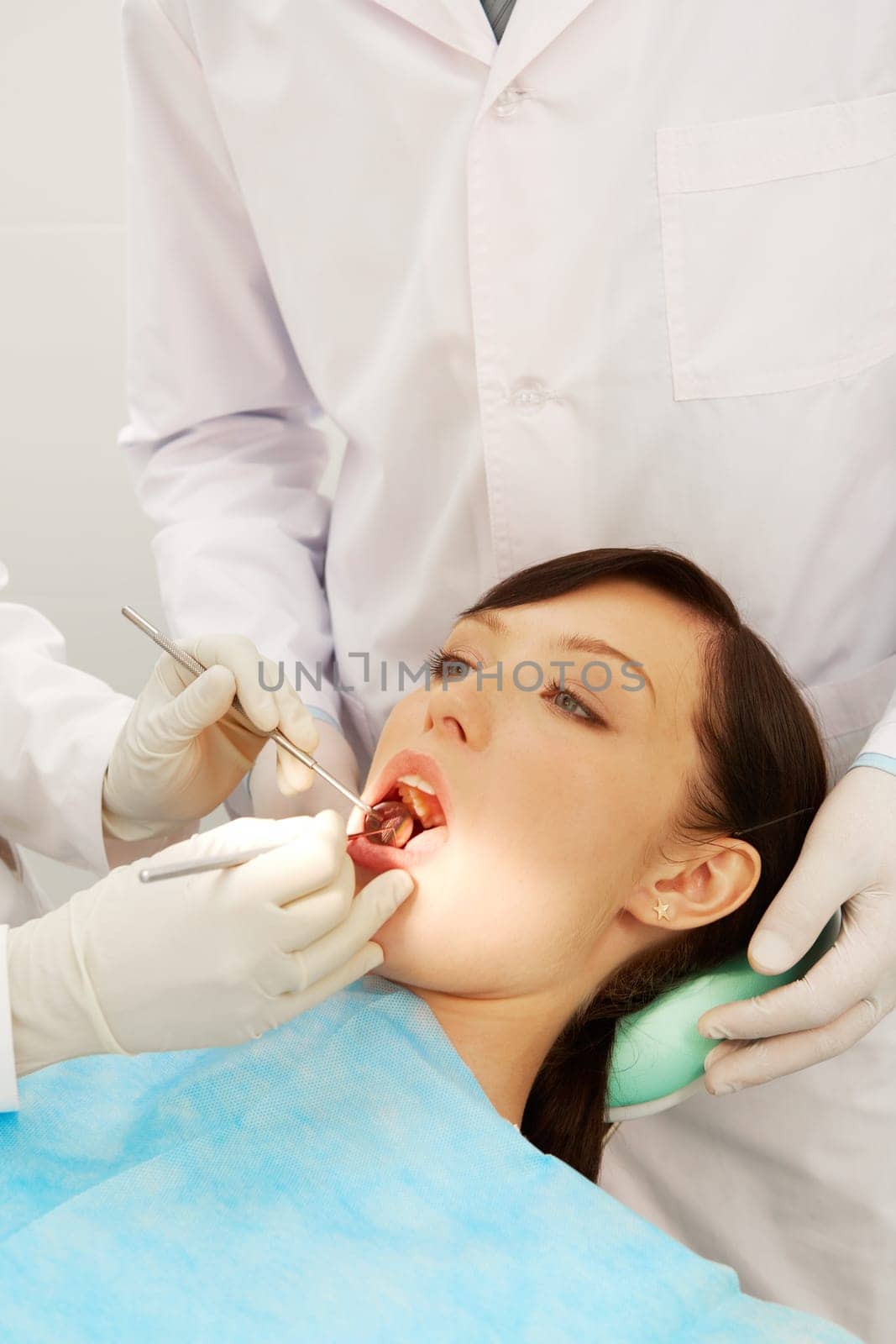 Image of a girl examined by two dentists