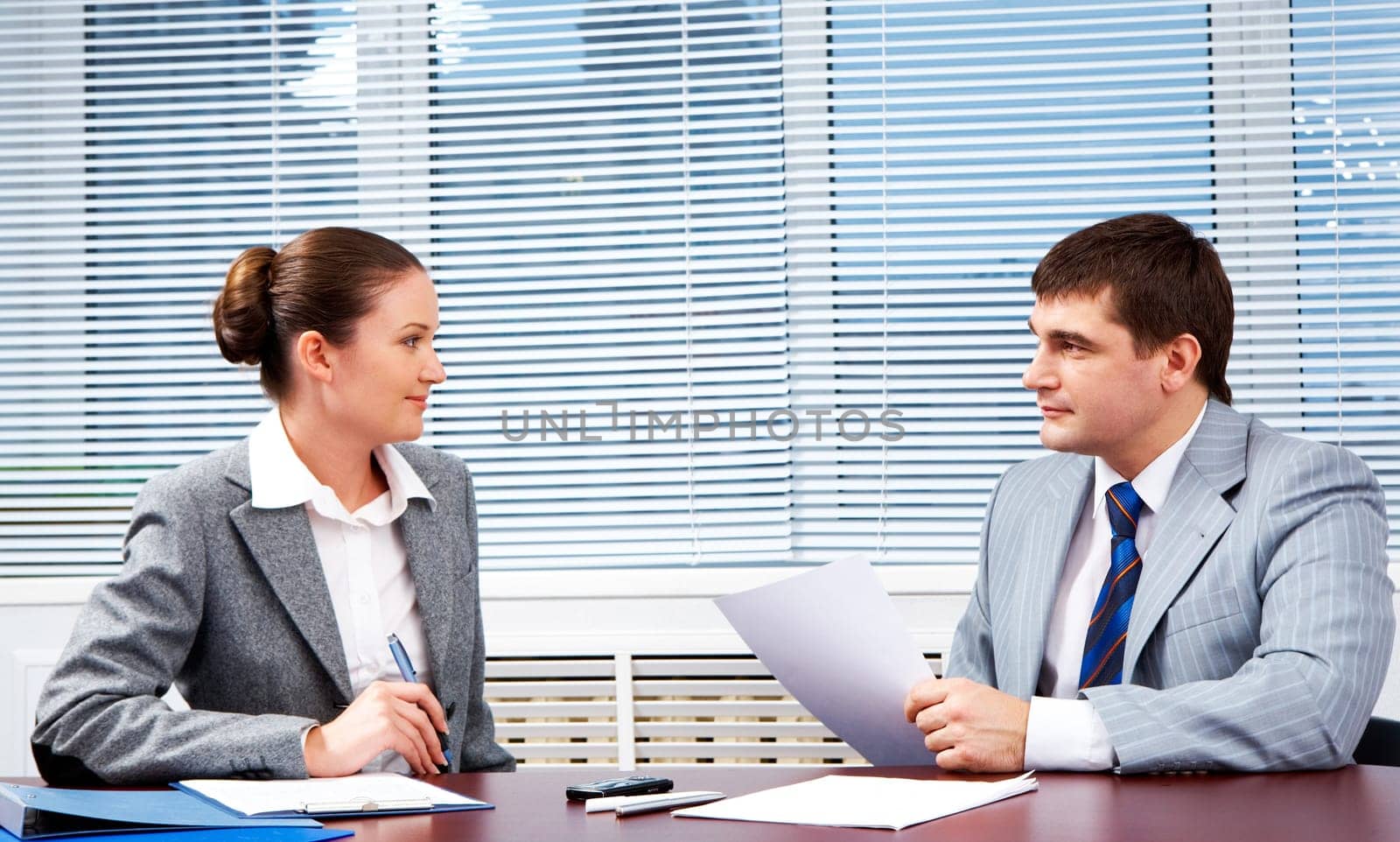 Photo of confident business partners looking at each other during formal communication