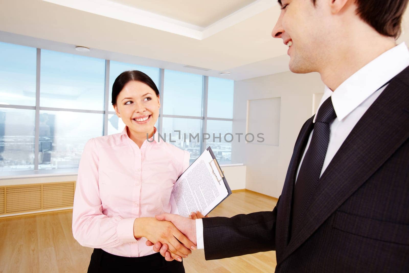 Photo of happy partners handshaking after signing contract