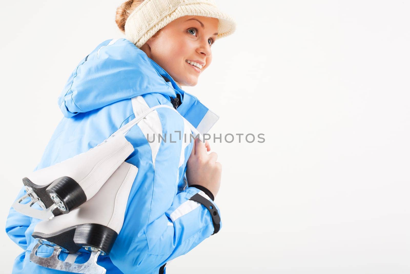 Portrait of young woman holding skates on a white background