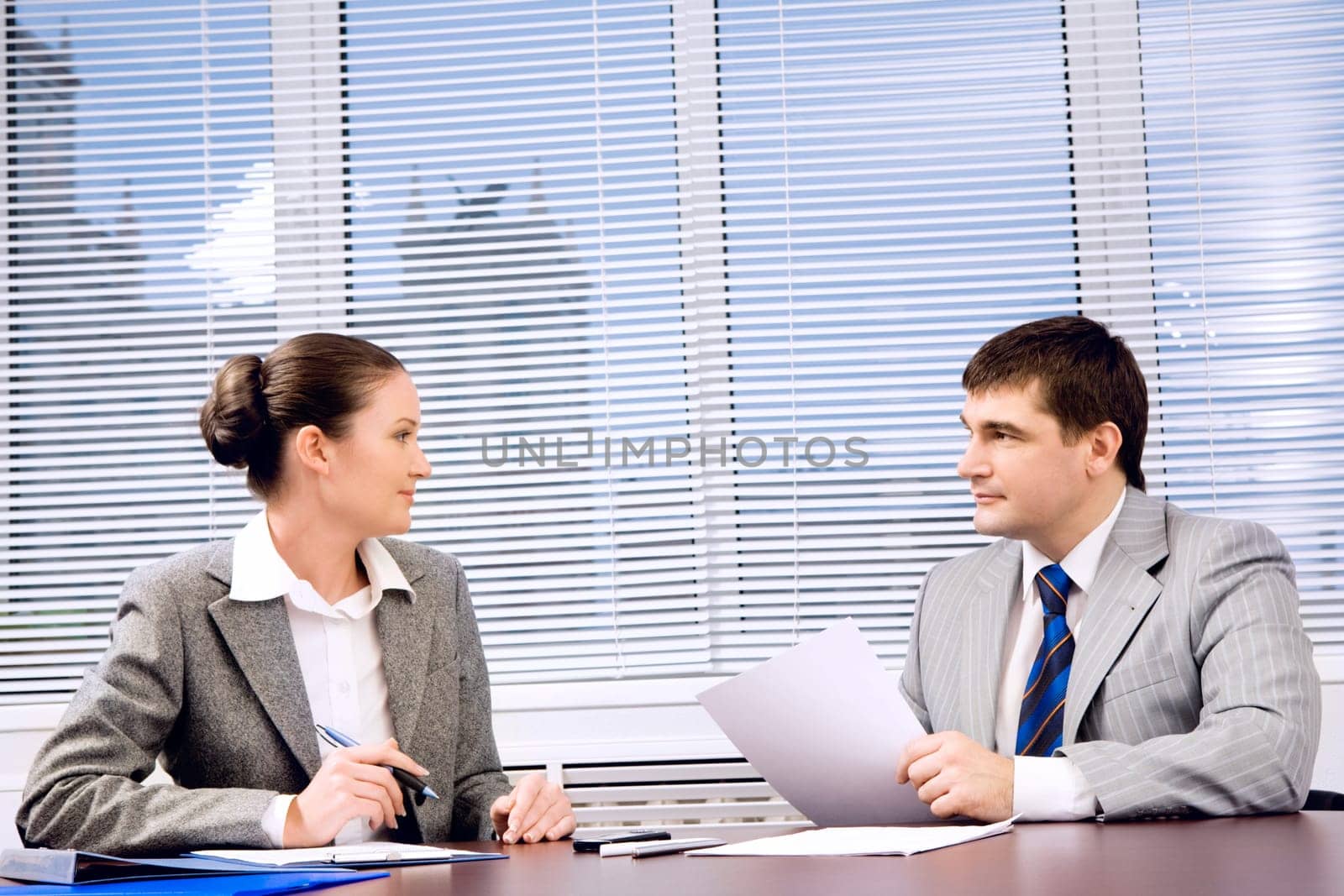 Photo of confident business partners looking at each other during formal communication