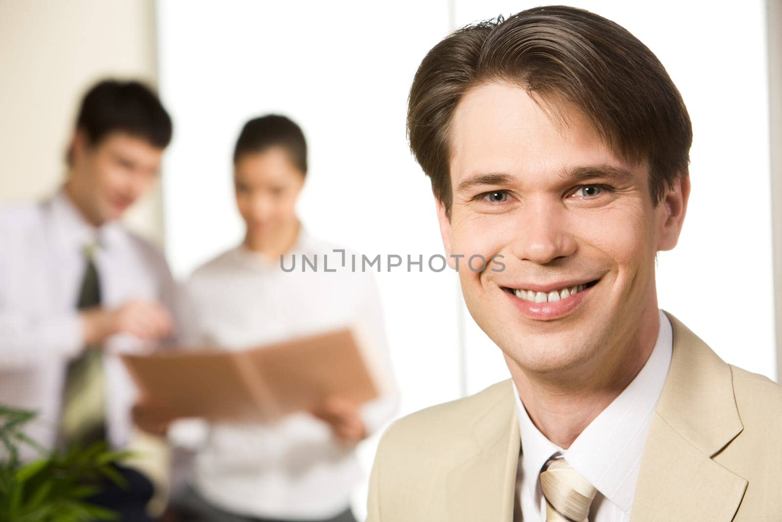 Portrait of people working with smiling businessman in front