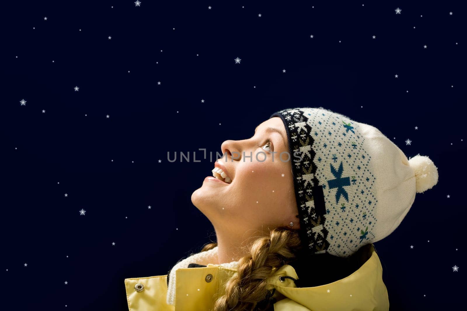 Portrait of amazed girl looking at falling snowflakes