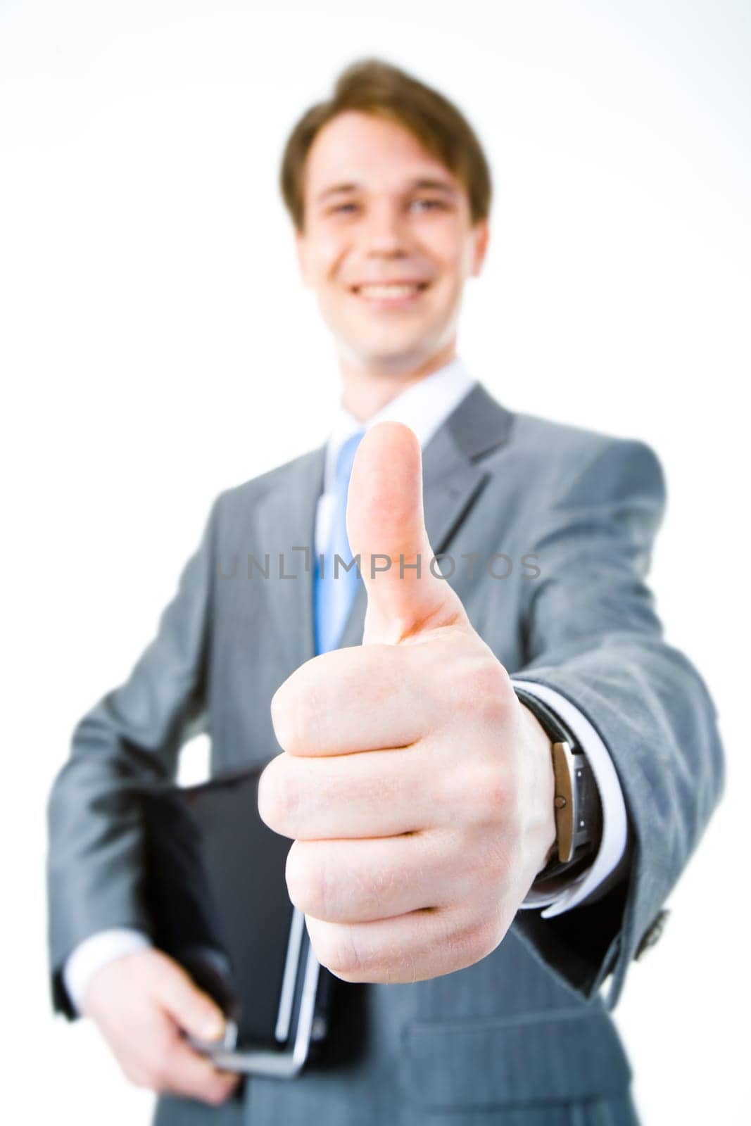 Close-up of businessmans hand showing thumb up on the background of male with laptop
