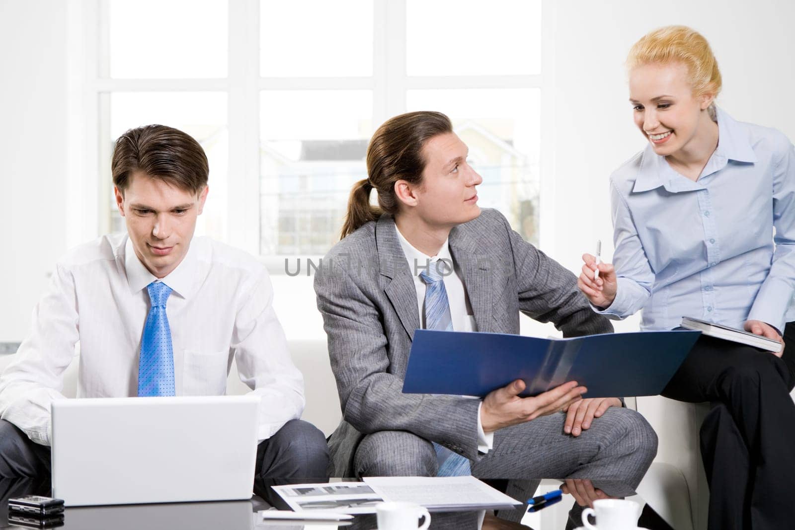 Image of executive employees consulting about new project while businessman typing on laptop