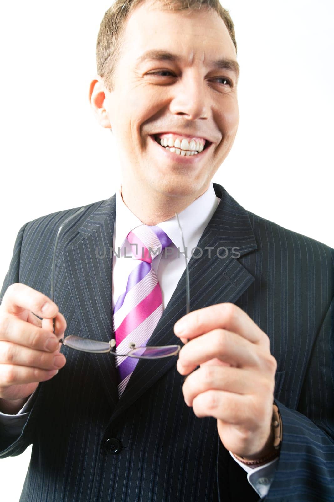 Portrait of happy businessman looking aside with glasses in hands