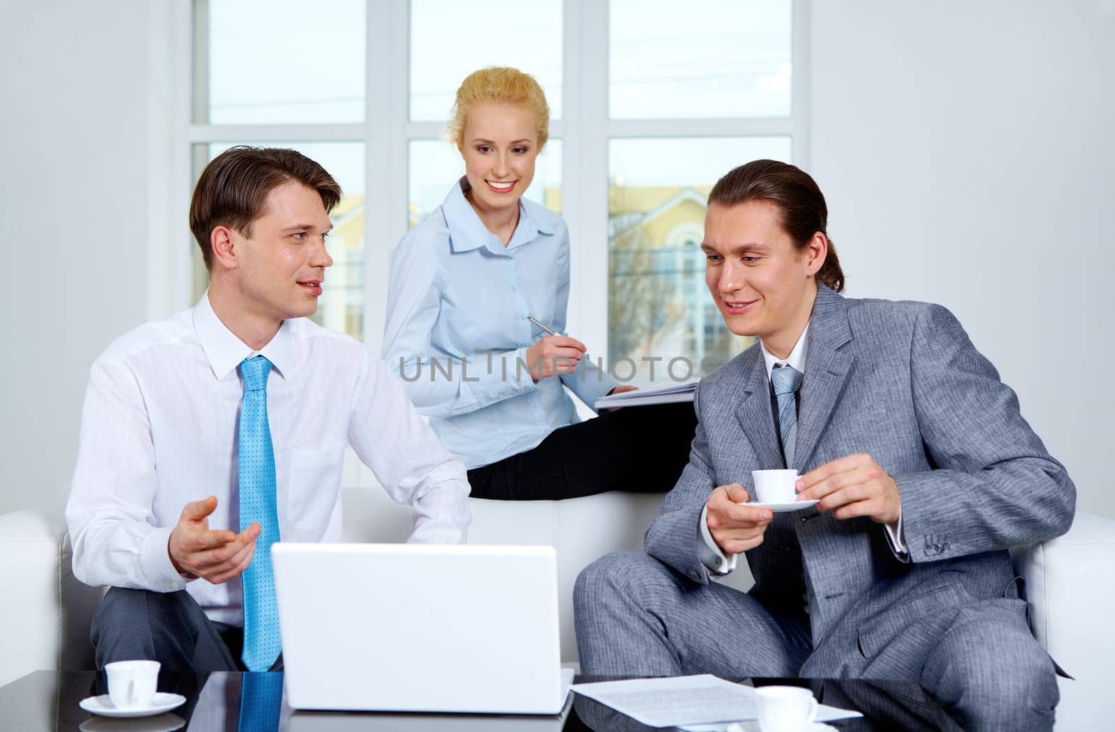 Portrait of successful co-workers sharing their ideas near laptop at meeting
