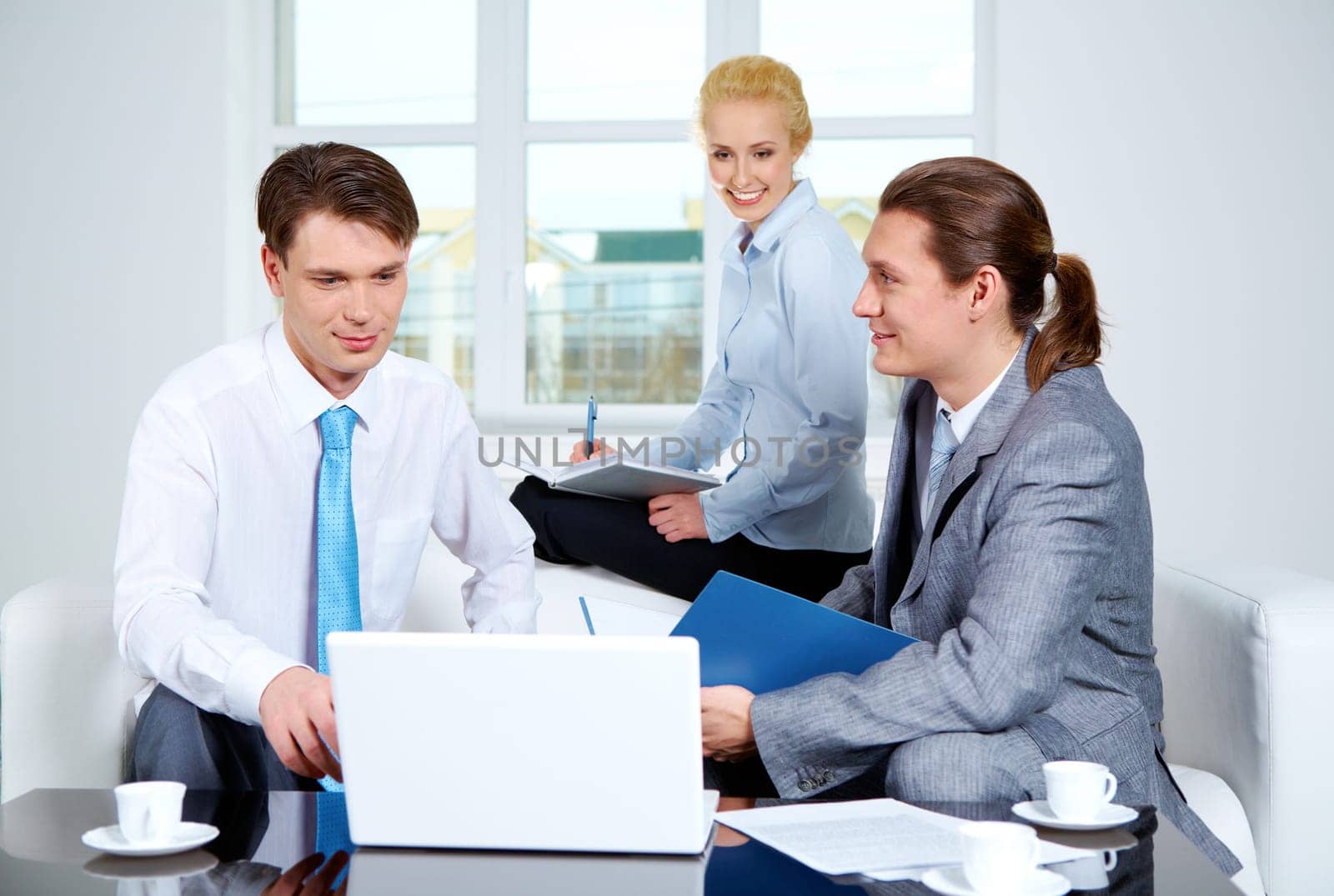 Portrait of successful co-workers sharing their ideas in office at meeting