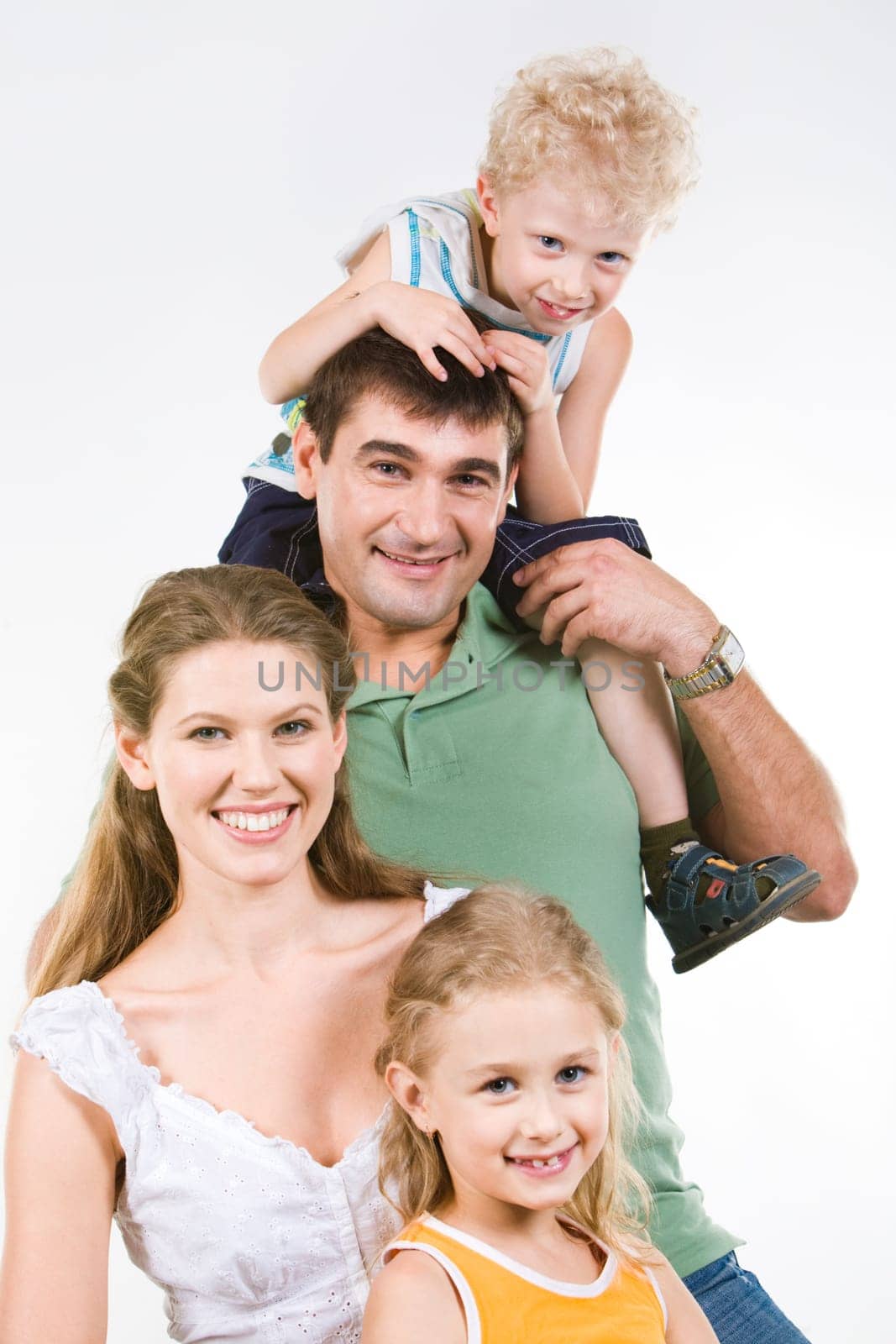 Portrait of boy sitting on neck of father with mother and sister near by