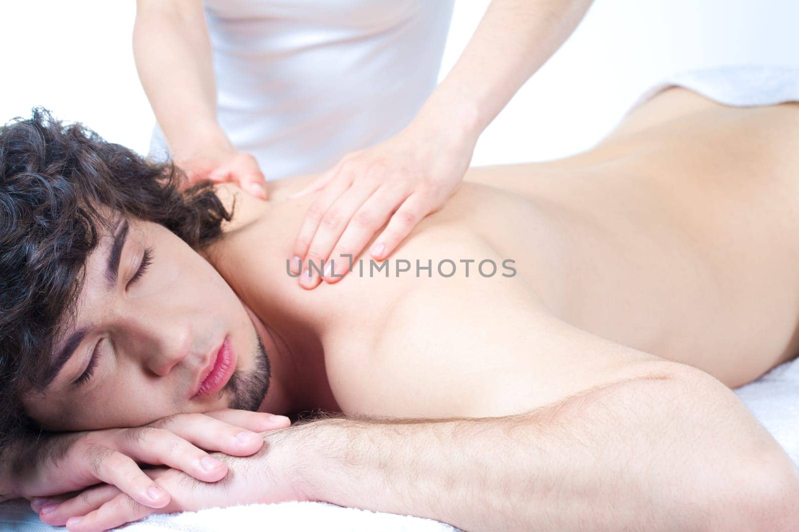 Portrait of young man with closed eyes and getting a relax massage