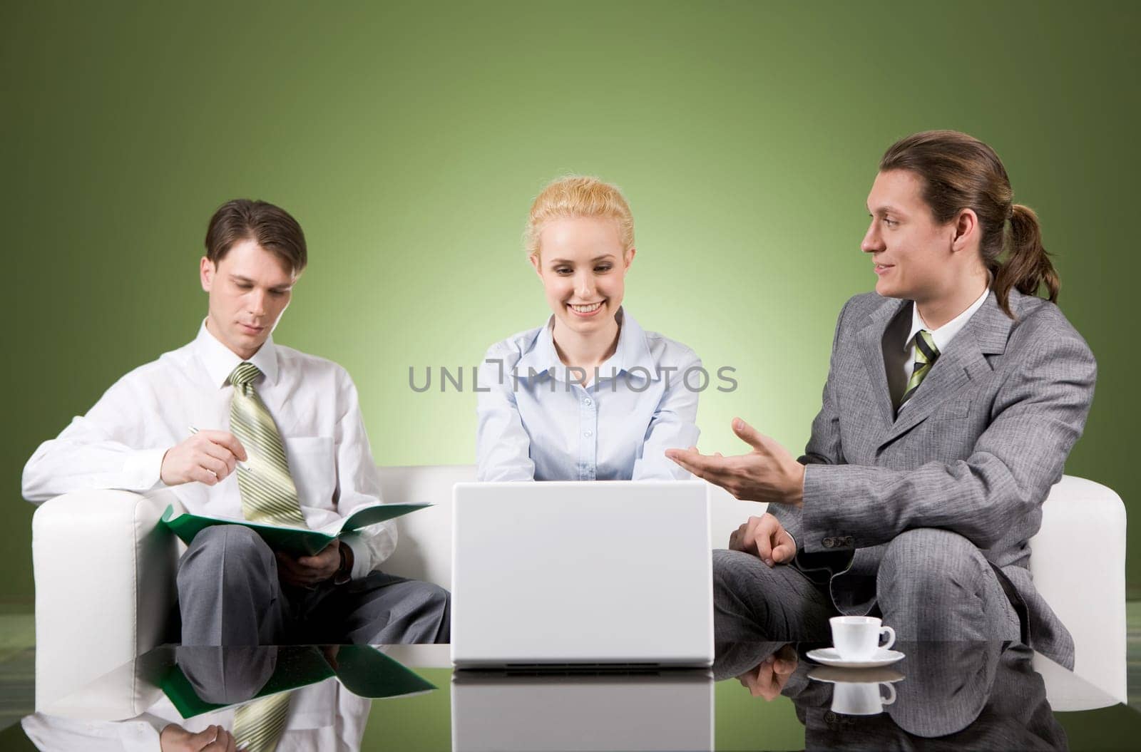 Portrait of businesspartners communicating at meeting with their colleague sitting near by