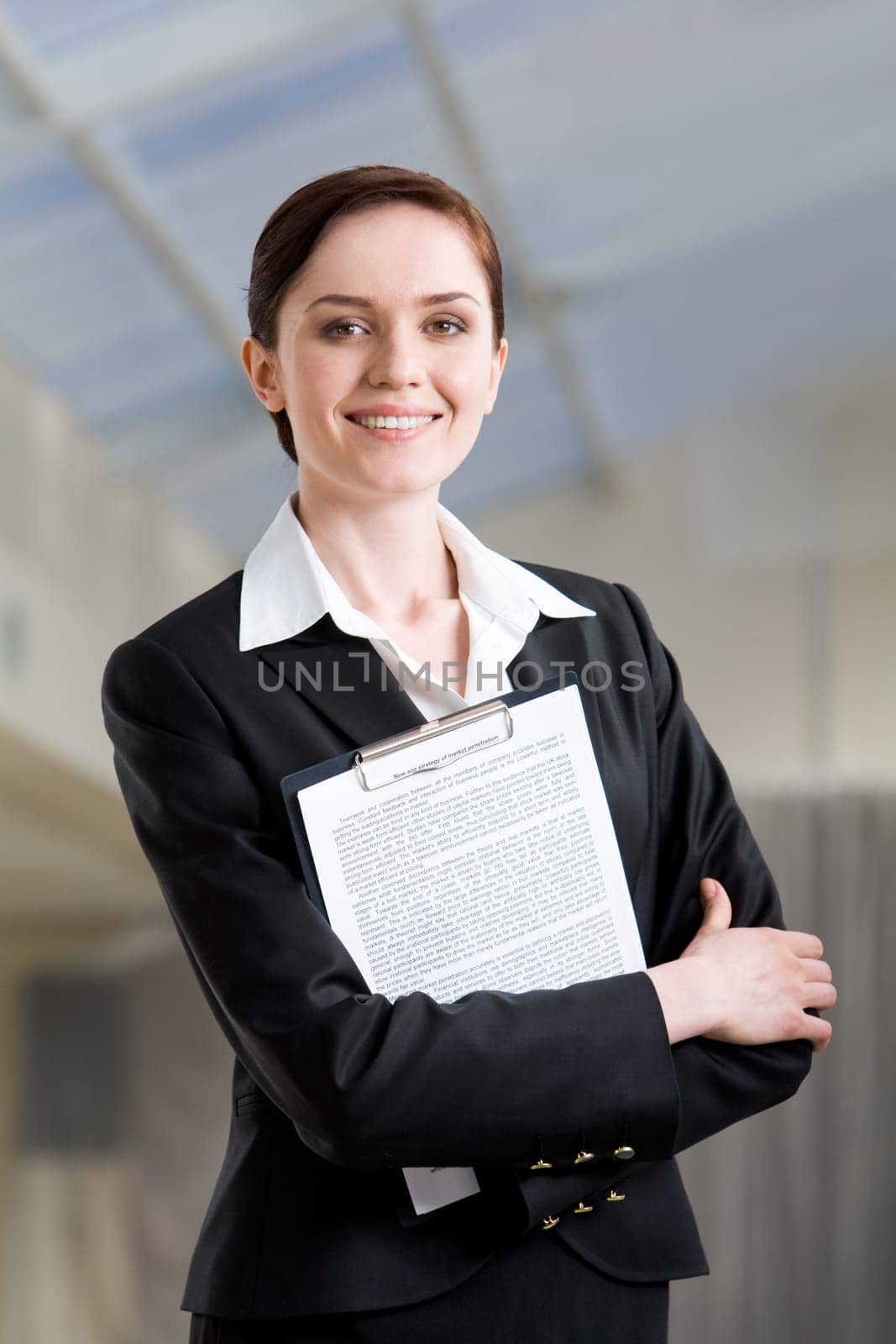 Portrait of pretty female with folder in hands looking at camera with smile