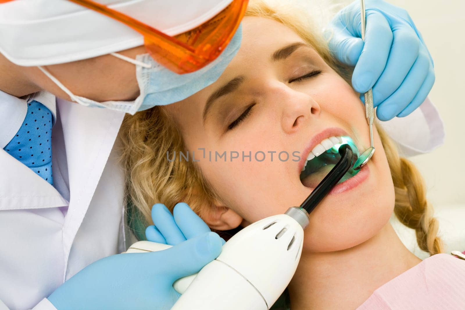 Close-up of beautiful female with open mouth having her teeth healed