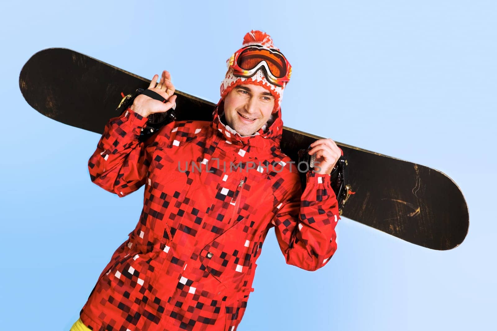 Portrait of happy man with skateboard over blue background