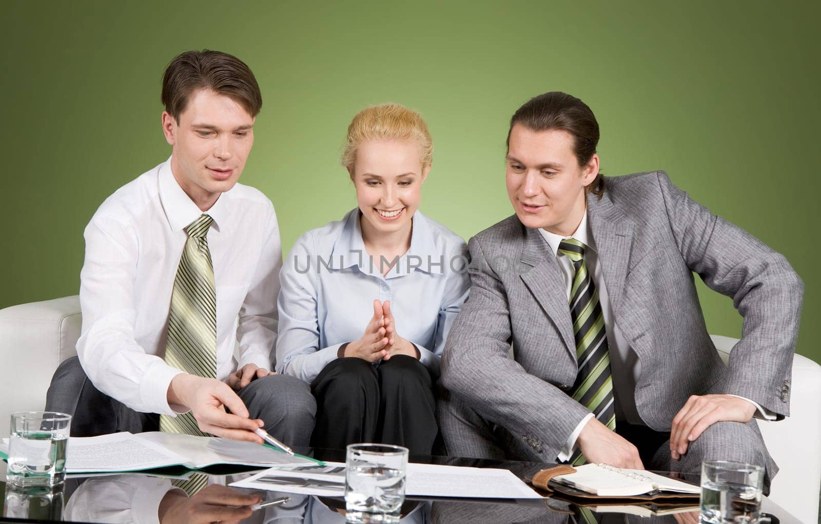 Photo of three co-workers discussing documents and brainstorming