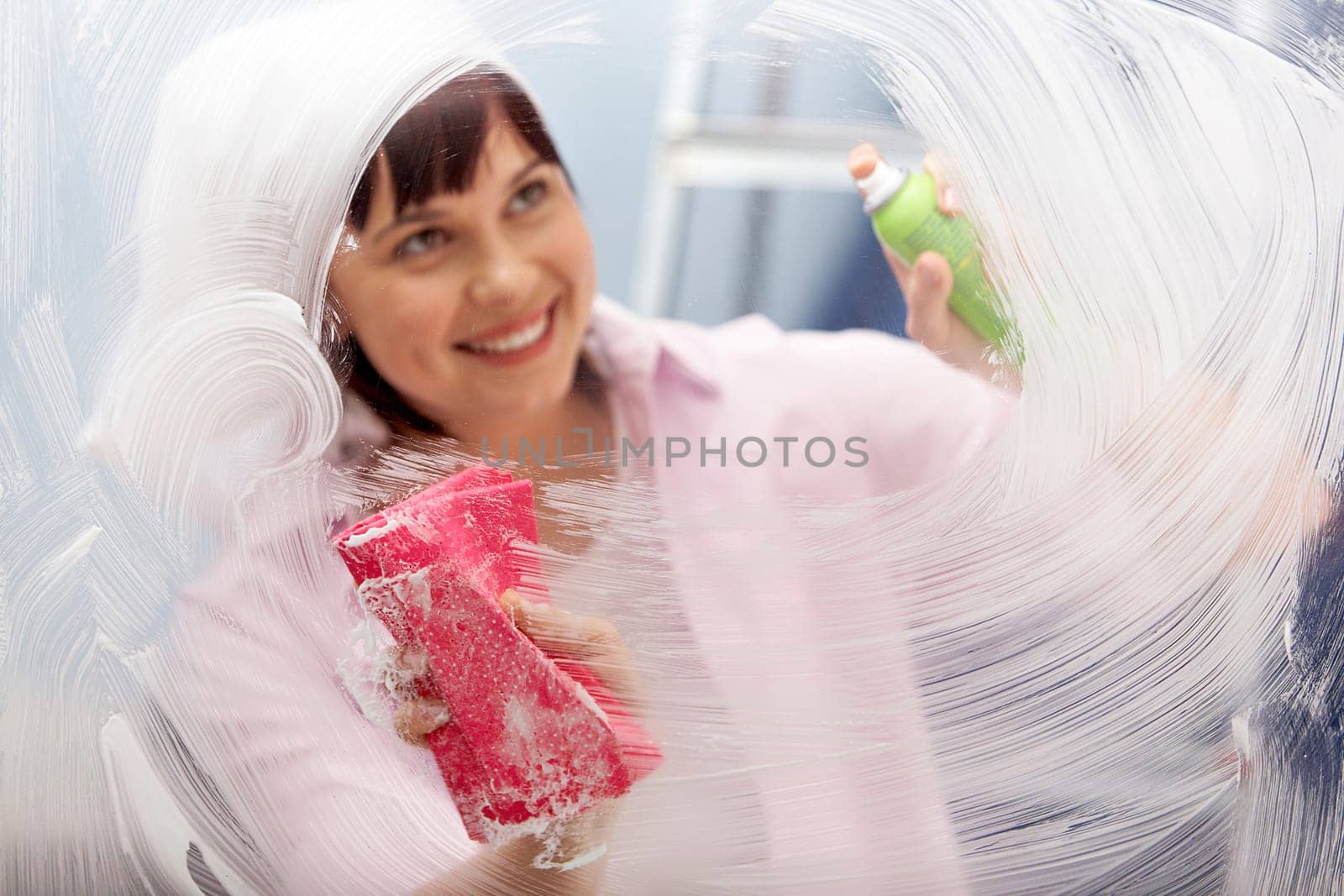 Portrait of a woman washing window