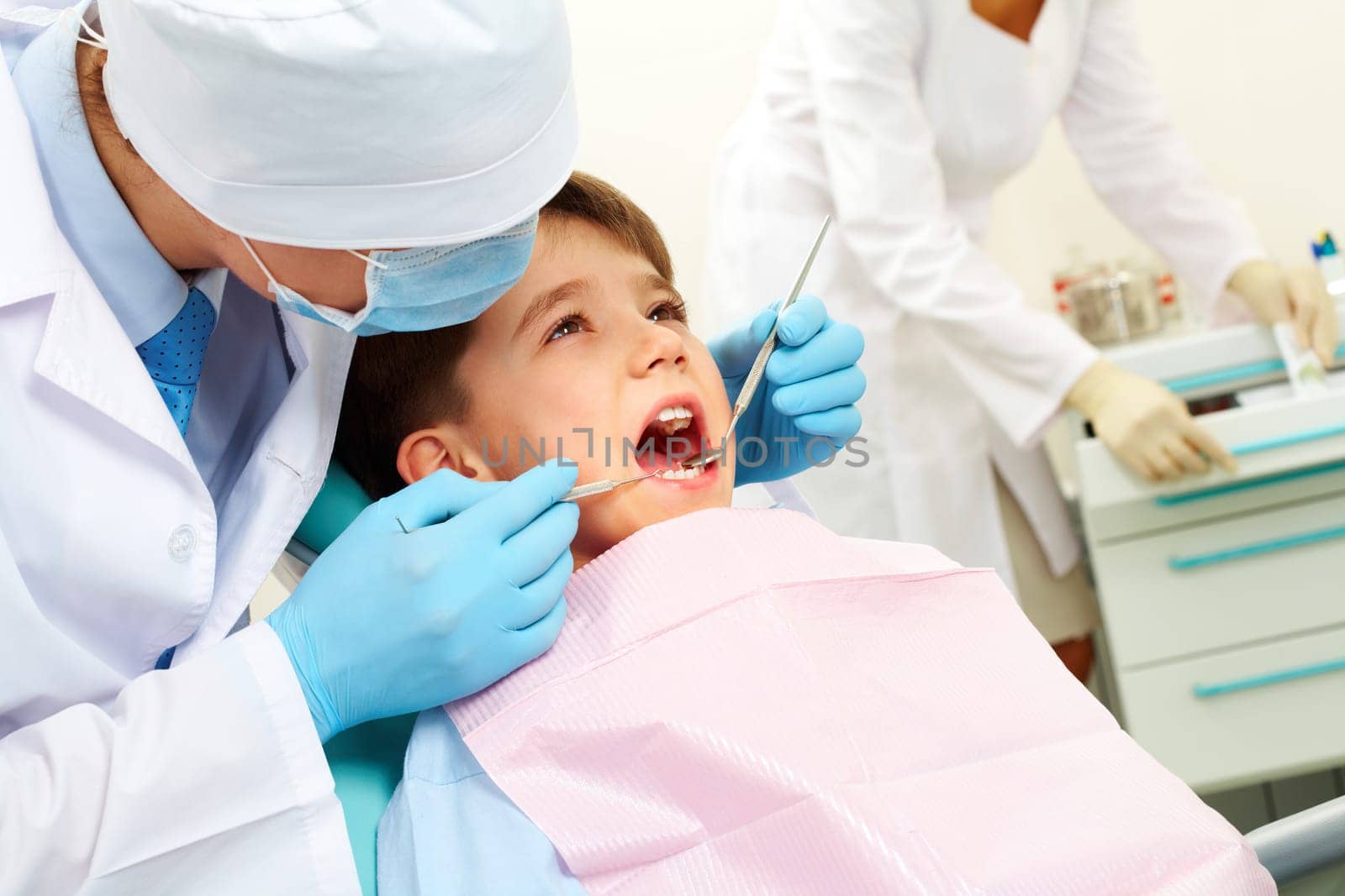 Image of dental examining being given to little boy by dentist