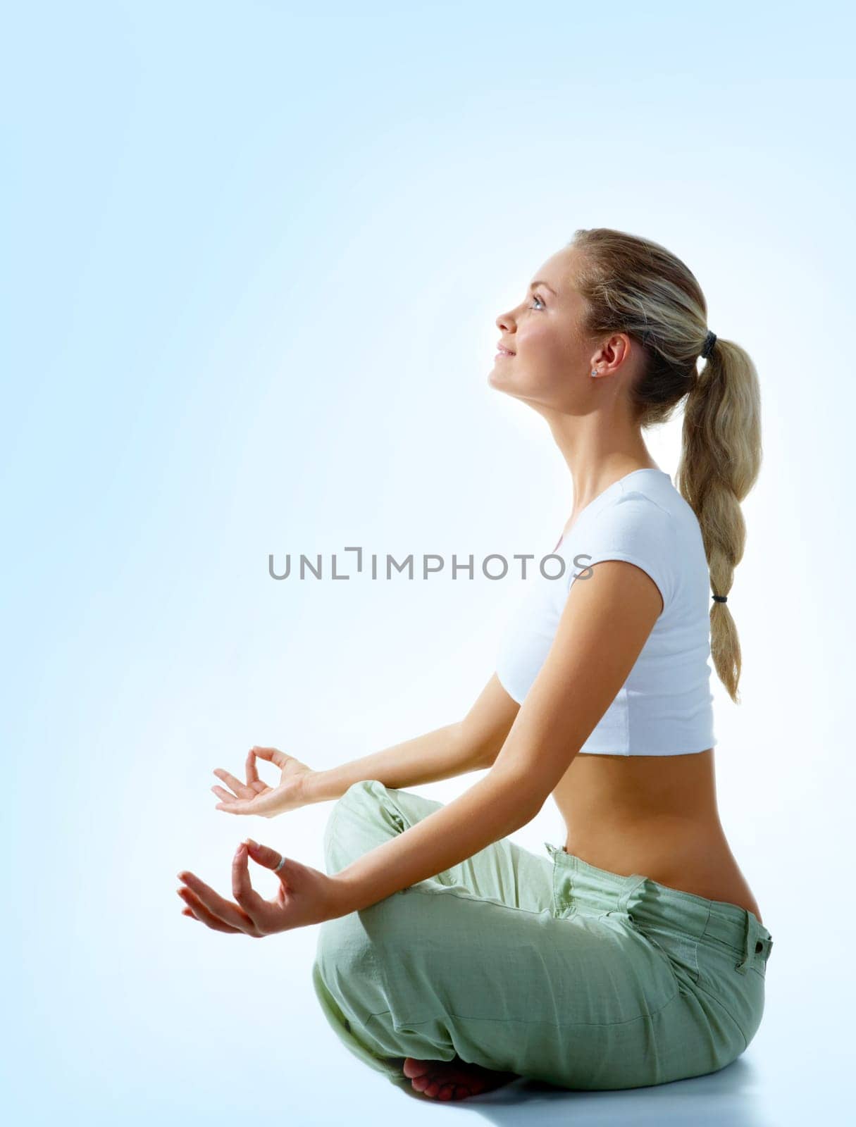 Profile of woman meditating in pose of lotus in isolation