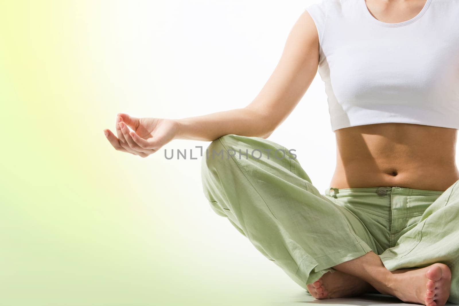 Close-up of females torso during meditation with legs crossed and hand being kept on her right knee