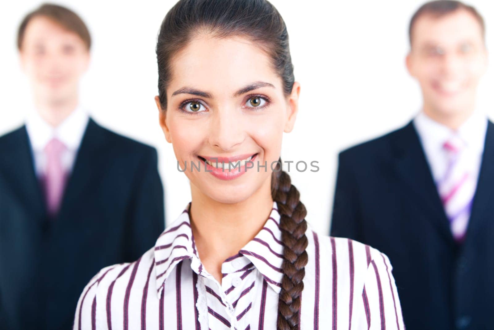Portrait of smiling woman looking at camera on the background of two businessmen