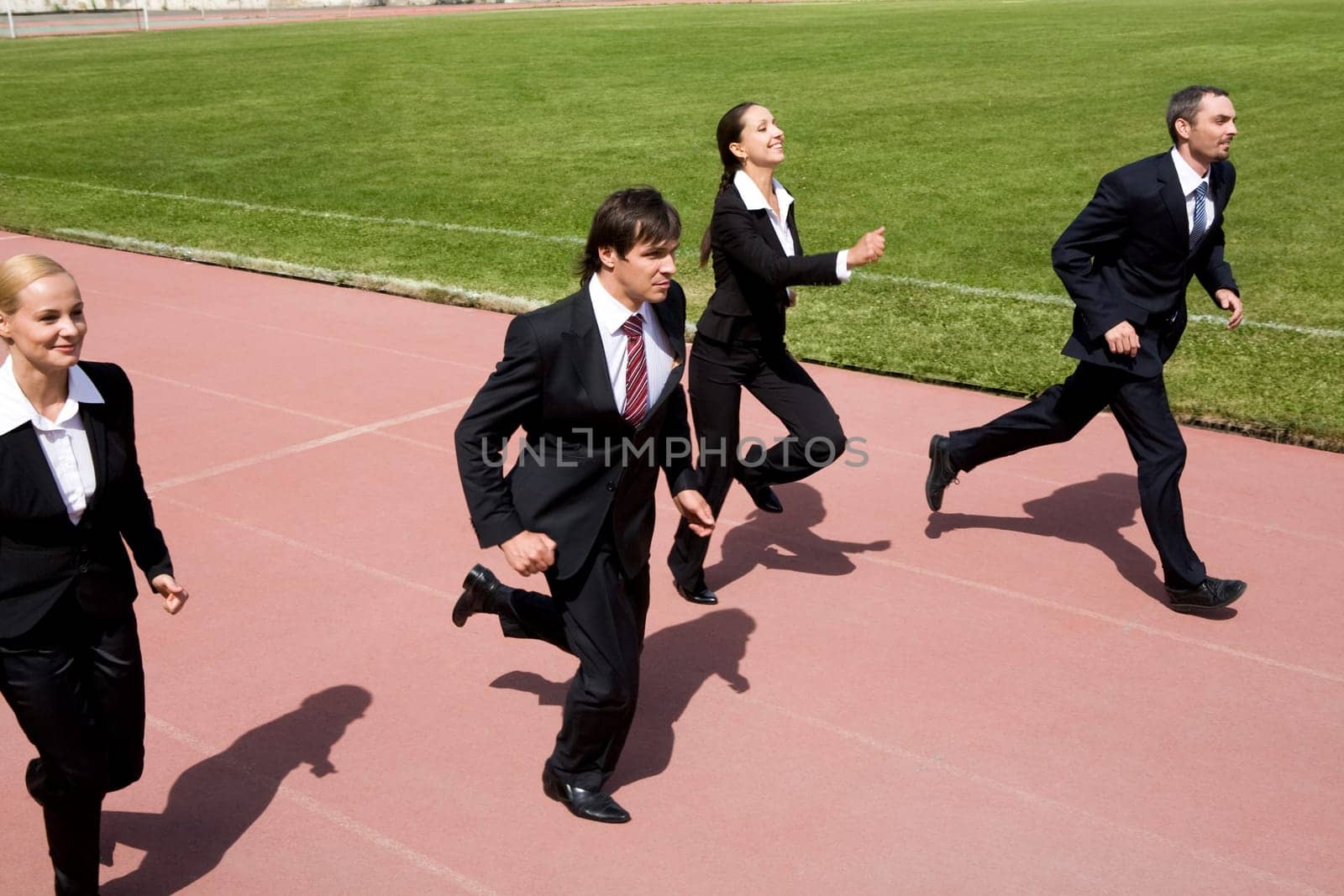 Photo of business people running on sport track
