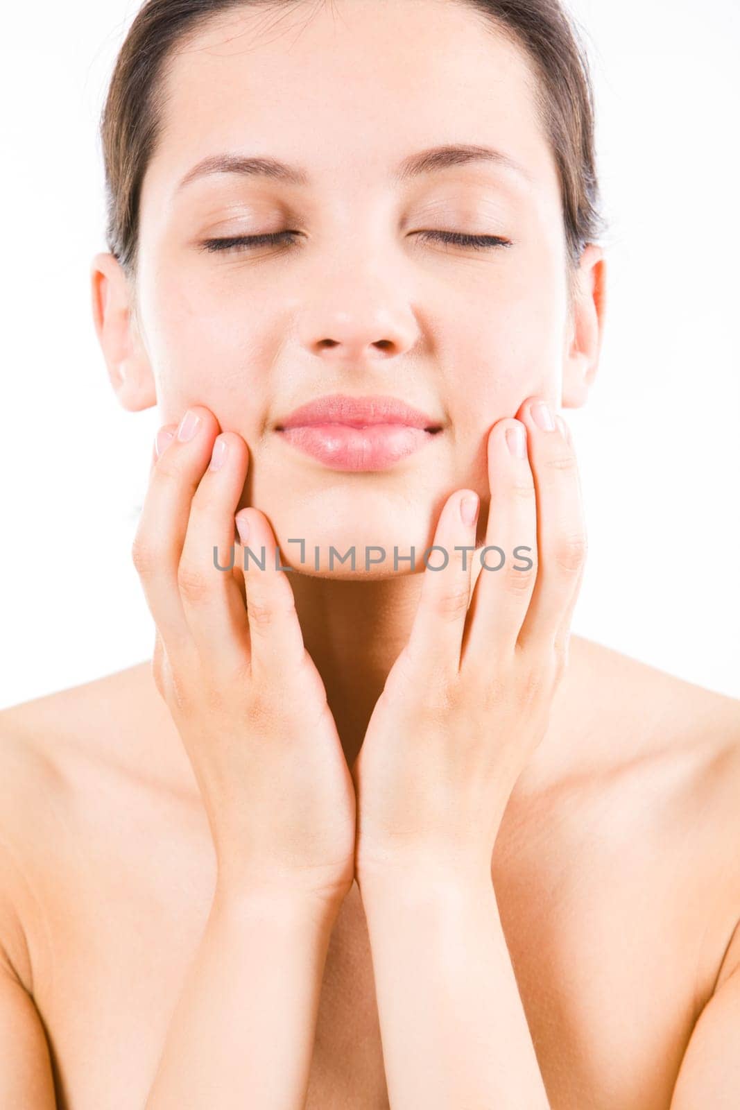 Close-up of pretty young woman touching her face