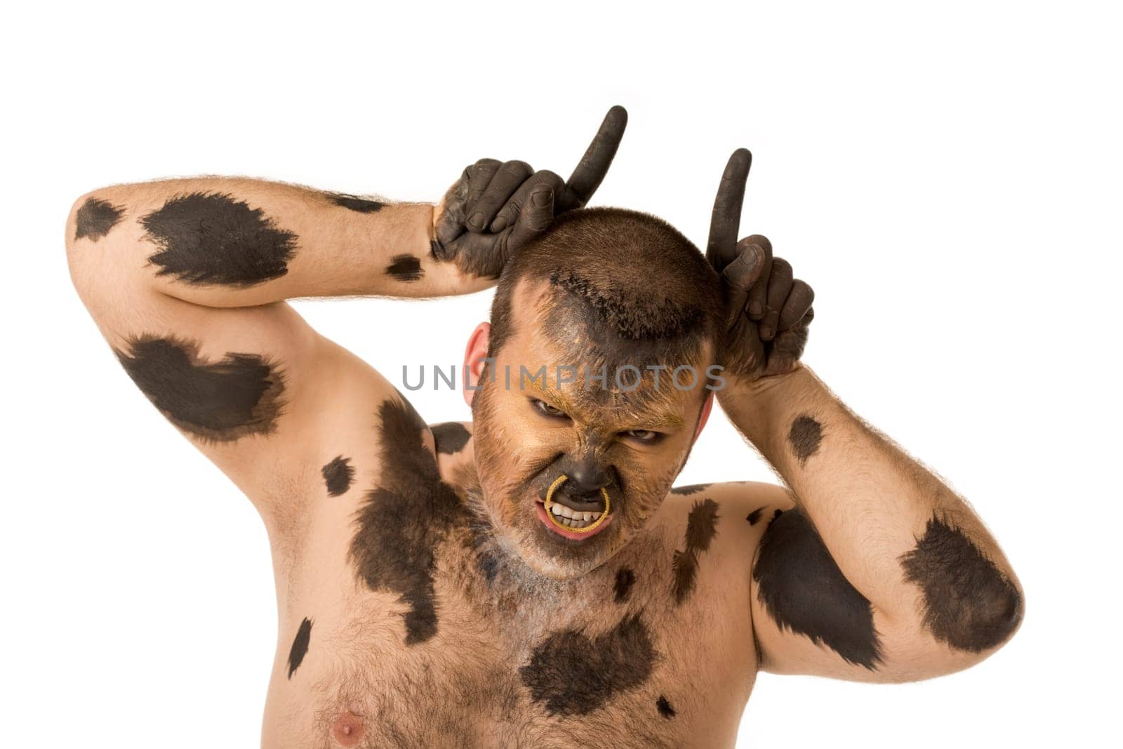 Portrait of painted man showing horns and looking at camera with aggressive grimace