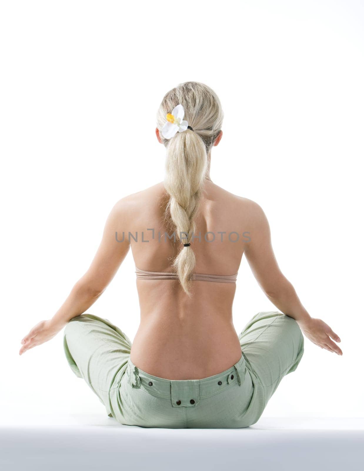 Rear view of meditating woman sitting over white background