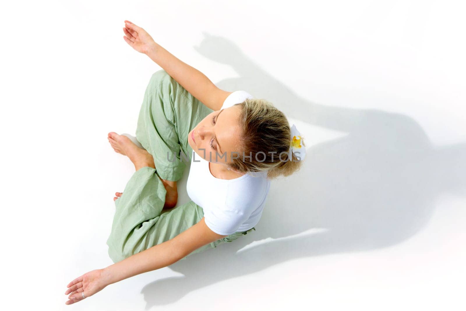 Above view of young woman meditating in pose of lotus