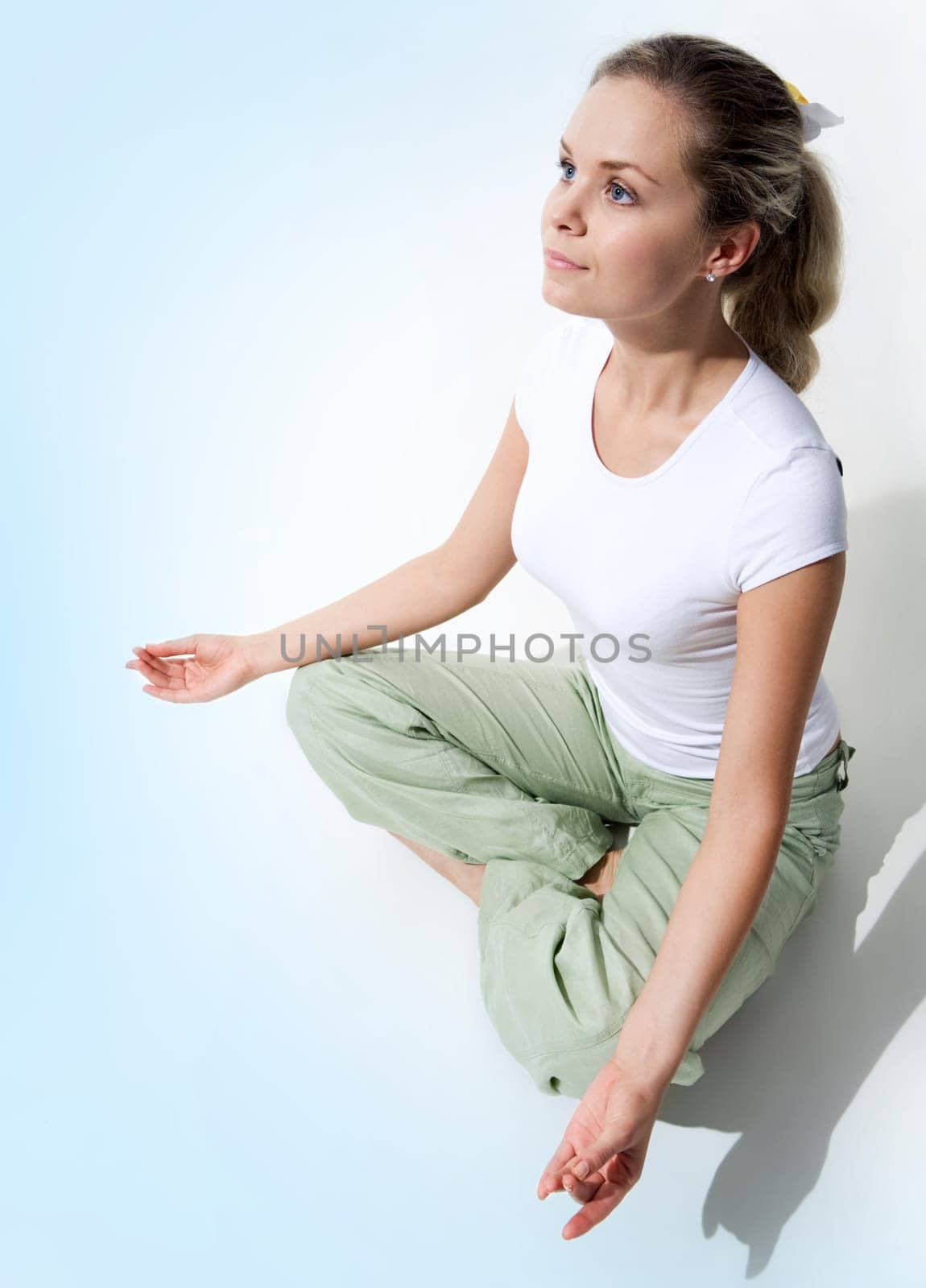 View from above of attractive woman sitting in pose of lotus