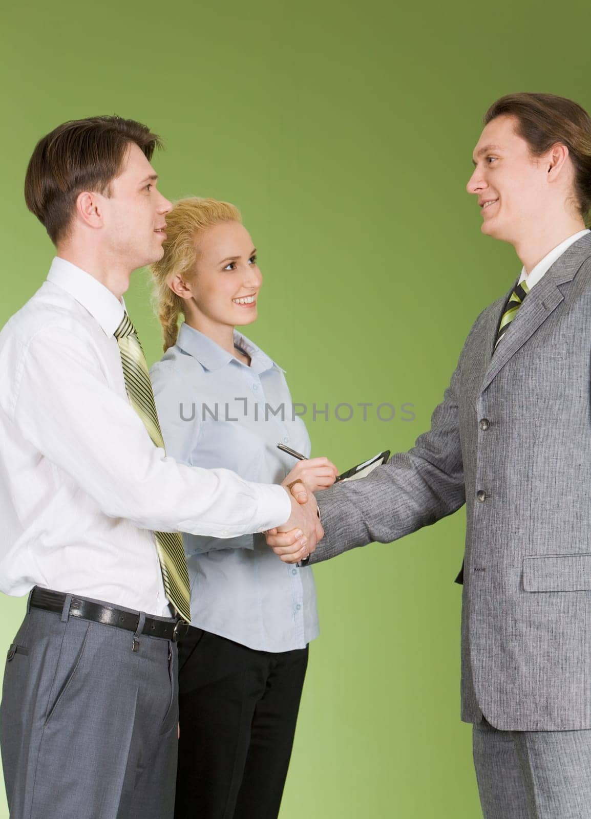 Portrait of two businessmen shaking hands after signing contract with pretty secretary standing near by