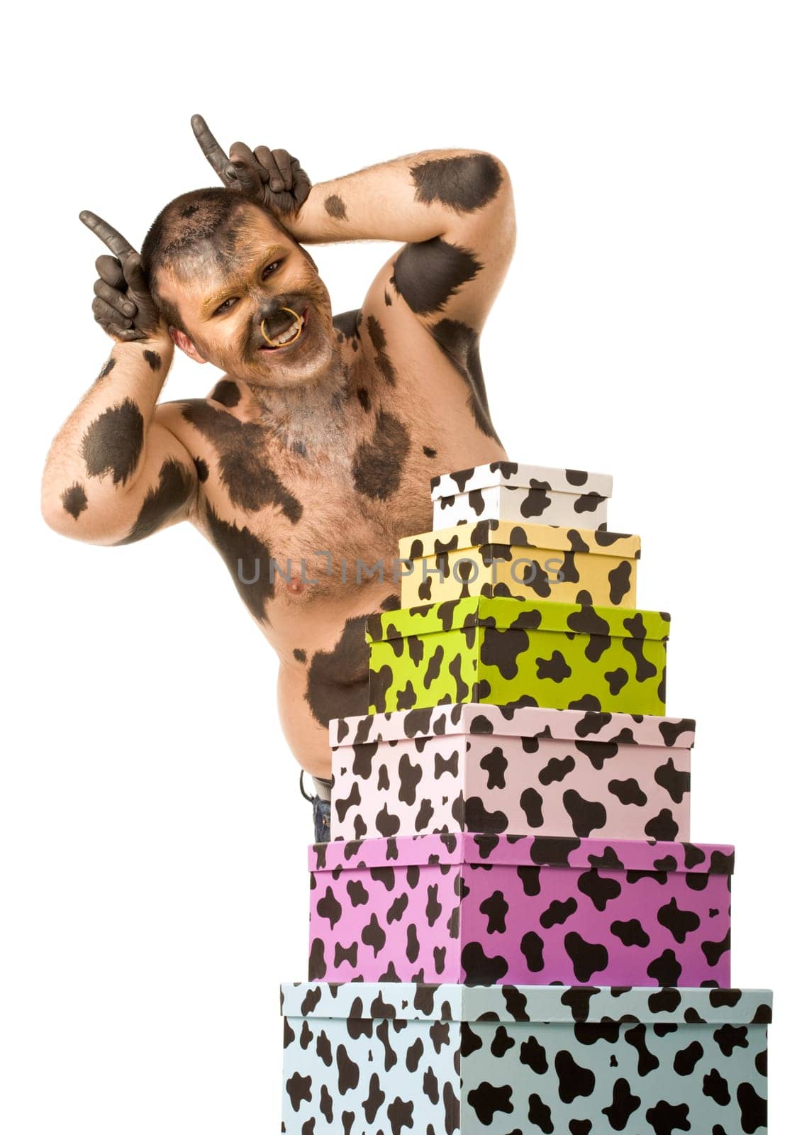 Portrait of happy man expressing himself as bull standing by heap of giftboxes