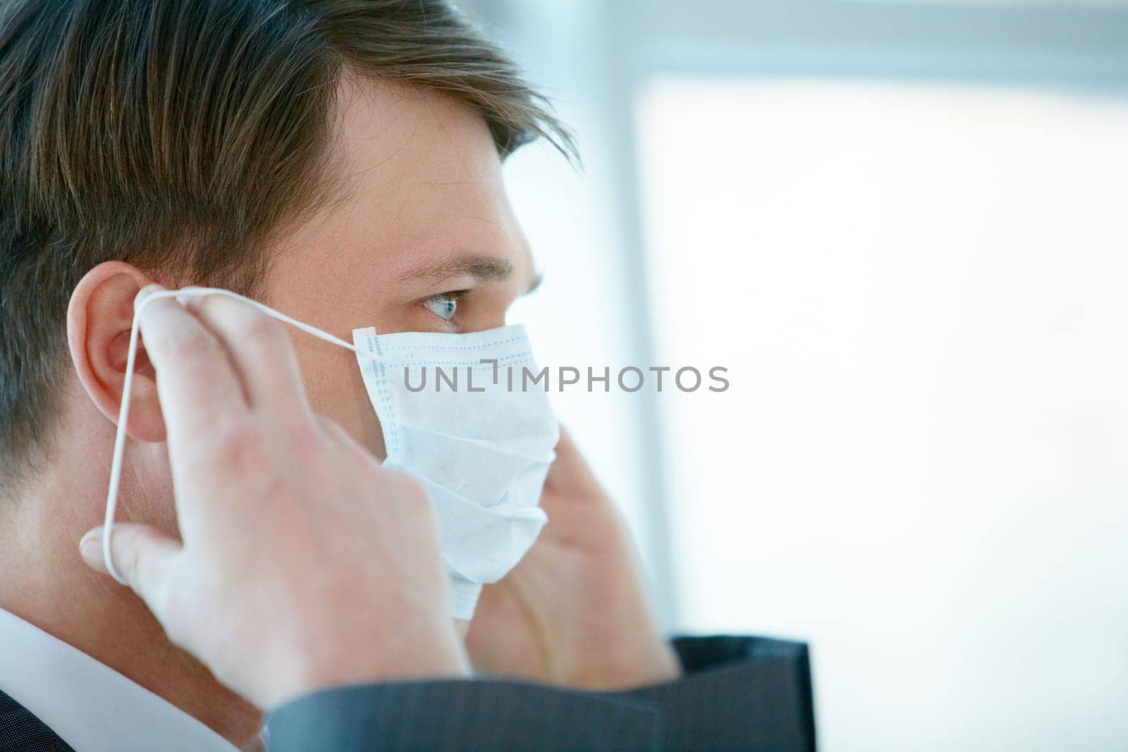 Portrait of businessman putting protective mask on his face
